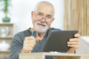 senior customer holding tablet computer at home