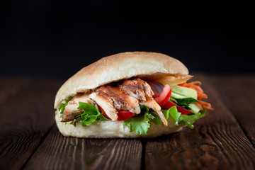 close up of kebab sandwich on wooden background