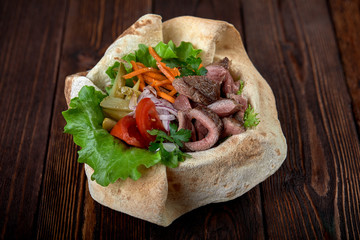 Turkish and Arabic Traditional Ramadan mix kebab plate. Kebab beef on lavash bread with sauce and vegetables.