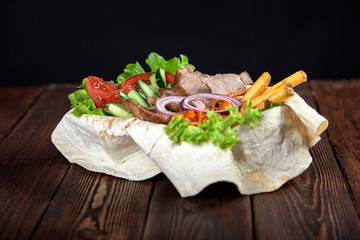 Turkish and Arabic Traditional Ramadan mix kebab plate. Kebab beef on lavash bread with sauce and vegetables.