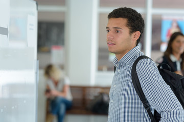 young man looking at announcement on the wall