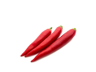 Three fresh and healthy chili peppers of different colors isolated on white background. Selective focus.