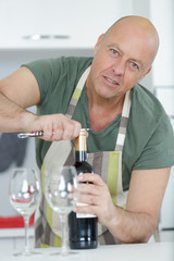 man opening wine bottle in the wine cellar