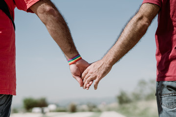 Two gay men shake hands with an LGBT bracelet.LGTB,LGBT
