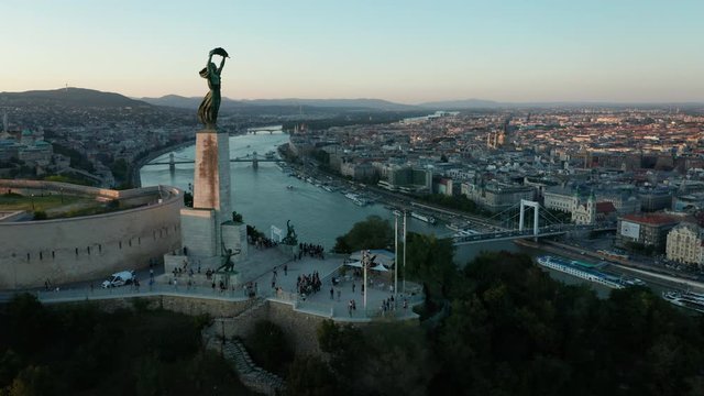 flying past Liberty Statue towards dusk view of Budapest