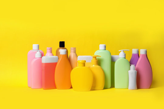 Different bottles of shampoo on yellow background. Natural cosmetic products
