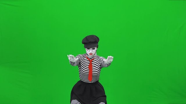 Mime girl acting like she athlete, lifting weight. Chroma key.
