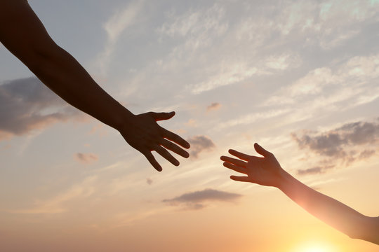 Man giving hand to woman outdoors, closeup. Help and support concept