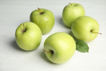 Fresh ripe green apples on white wooden table