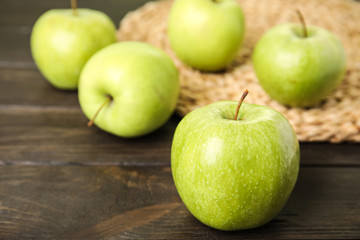 Fresh ripe green apples on wooden table, space for text