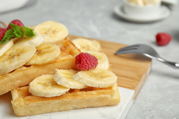 Delicious waffles with fresh berries served on white marble table