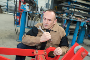 middle-aged mechanic working with spanner