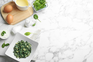 Flat lay composition with tasty spinach and space for text on white marble table. Healthy food