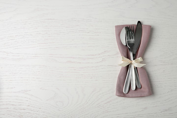 Cutlery set for festive table on white wooden background, top view. Space for text