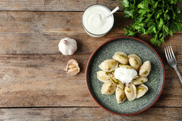 Delicious cooked dumplings served on wooden table, flat lay. Space for text