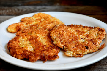 Chicken chops on a white plate, on a wooden table.