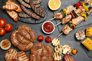 Flat lay composition with barbecued meat and vegetables on grey table