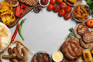 Frame of barbecued meat and vegetables on light table, flat lay. Space for text