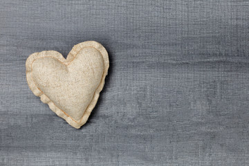 Handmade fabric heart on wooden background with copy space