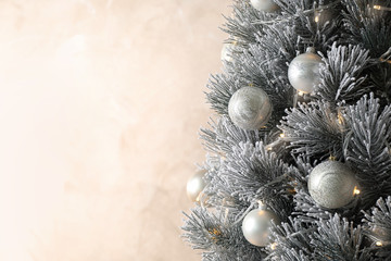 Fototapeta na wymiar Beautiful Christmas tree with decor on light background. Space for text