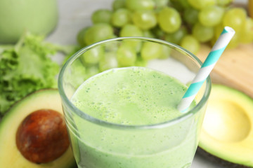 Glass of tasty avocado smoothie on table, closeup