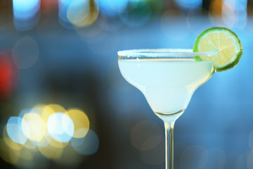 Glass of fresh alcoholic cocktail against blurred background. Space for text