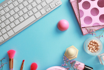 Flat lay composition with keyboard on blue background. Beauty blogger's workplace