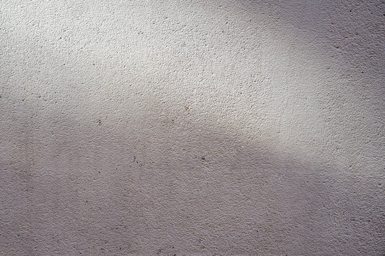 A wall with shadows and light beckground texture.