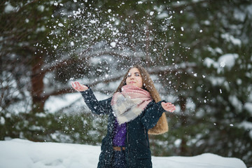 Fototapeta na wymiar Teenage girl playing with snow in an amazing winter.