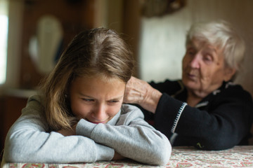 A crying little girl is comforted by her grandmother.