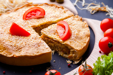 Fresh Traditional Australian meat mini pie on the wooden board on table background, closeup with copy space, top view, rustic style