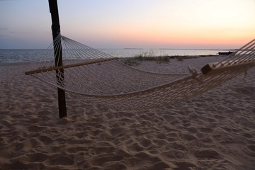 Empty hammock on beach at sunset. Time to relax