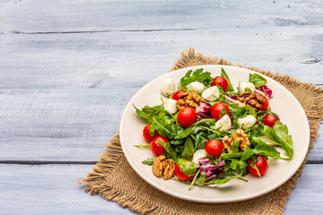 Fresh salad with arugula, radicchio, tomato cherry, baby mozzarella, walnuts