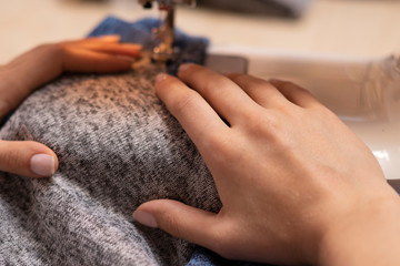 Seamstress at work. Sewing new clothes on a sewing machine.