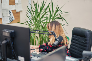 Woman prepares a news list in a radio broadcast studio.
