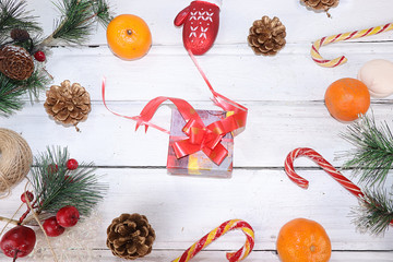 Christmas gift boxes on the festive table, flat lay, selective focus. Preparation for the New Year and Christmas with tangerines, Christmas toys, cones and sweets.