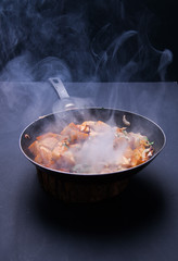 Fried meat in a frying pan closeup. Top view with copy space