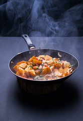 Fried meat in a frying pan closeup. Top view with copy space
