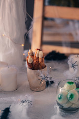 Spooky Halloween decoration with different pumpkins, light, spiders. Halloween table decoration.