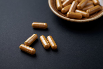 Turmeric capsules. Black background. Close up. Copy space. 