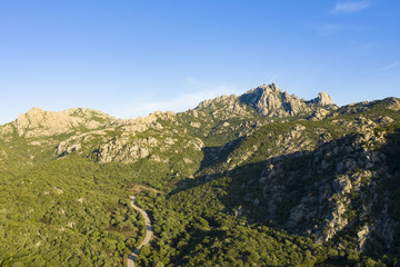 View from above, stunning aerial view of some granite mountains with a road running through them. Sardinia, Italy.