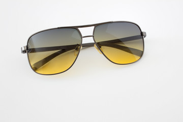 Close up of sun glasses with yellow shaded glass on white background. Photo with copy blank space.