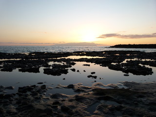 sunset over ponds at the sea