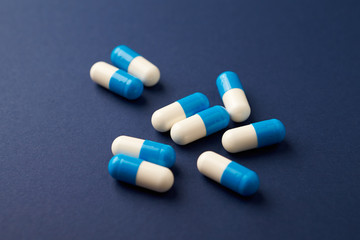 Tri-Creatine Malate capsules. Sports  supplements on blue paper background. Close up. 
