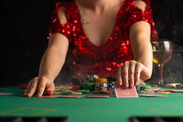 girl in evening dress plays poker in a casino. focus on the card and focus