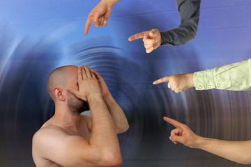 many hands show with an accusing gesture to a young man who covered his face with his hands, psychological concept, bullying, gaslighting, violence