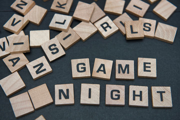 Letter tiles spelling out the words game night. - Powered by Adobe