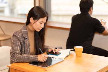 カフェでタブレットを見る女性