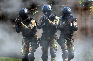 Special force assault team in a mission with smoke screen in background