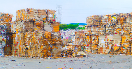 The recycle industry cardboard garbage and paper waste after pressing in hydraulic baling garbage press machine to a square dense for transportation to recycle factory